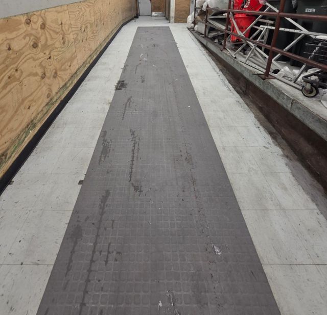 After: The same ramp floor cleaned, with a new anti-slip mat runner down the center
