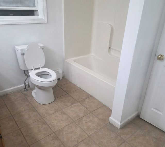 After: The same rental bathroom cleaned out and rent-ready, with tub, toilet and tile floor spotless